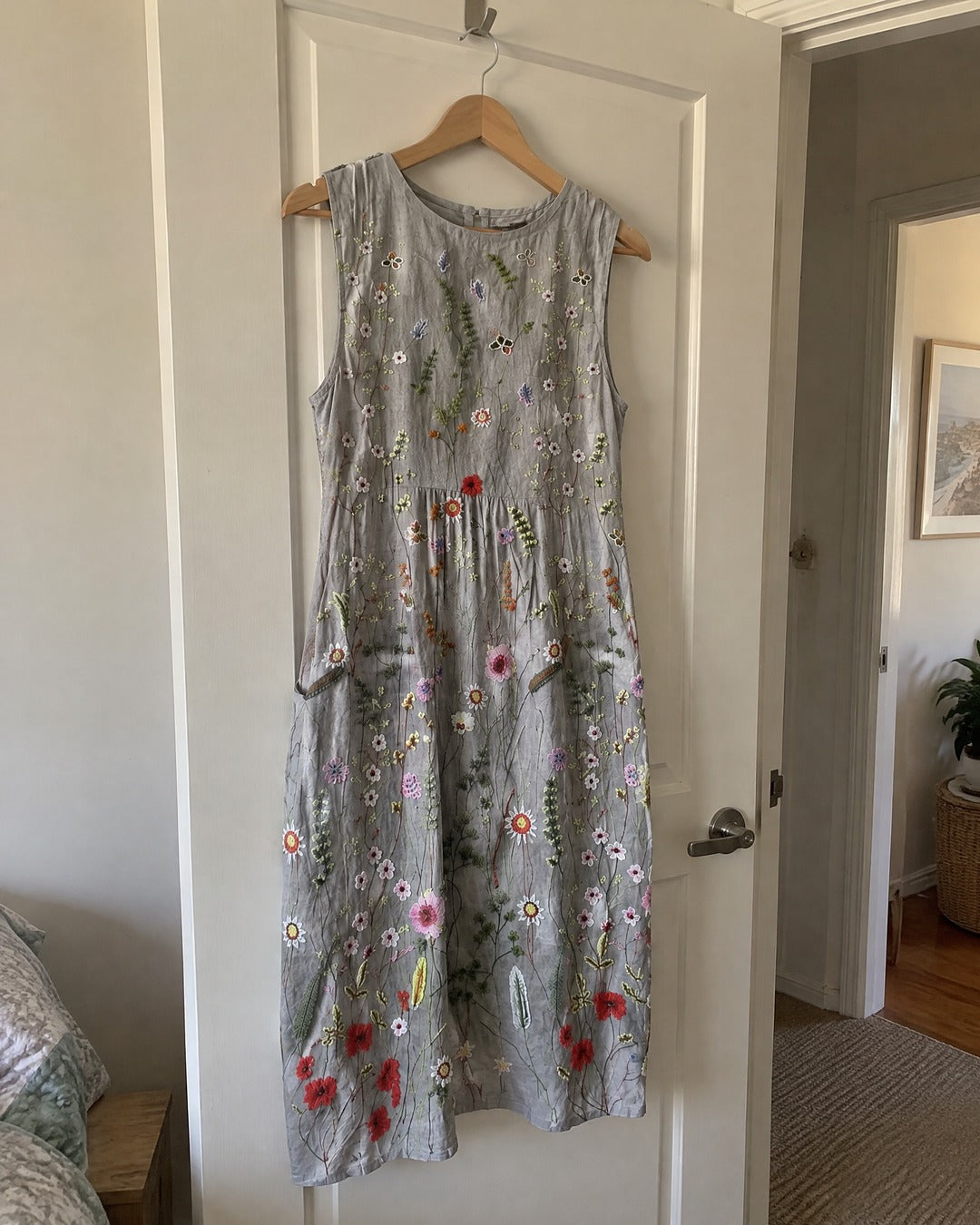 Agnes Wildflower printed midi dress hanging from a bedroom door