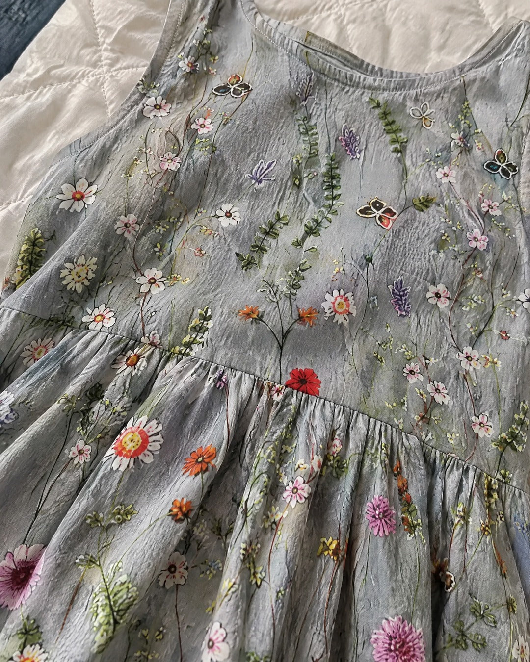Close view of Agnes soft grey wildflower fabric print and gathered waist seam