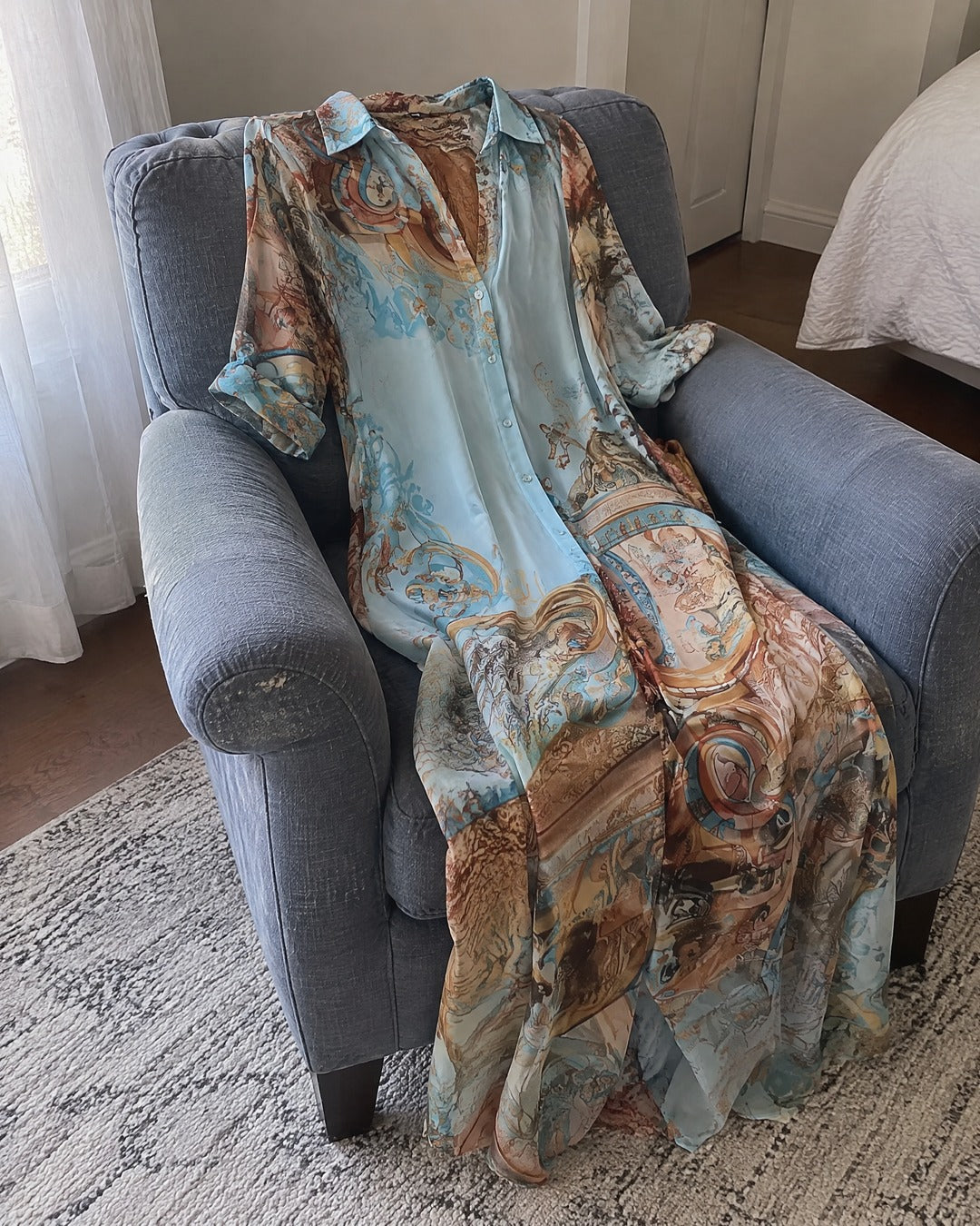 Isabella long button-front dress draped over a grey armchair in an everyday home