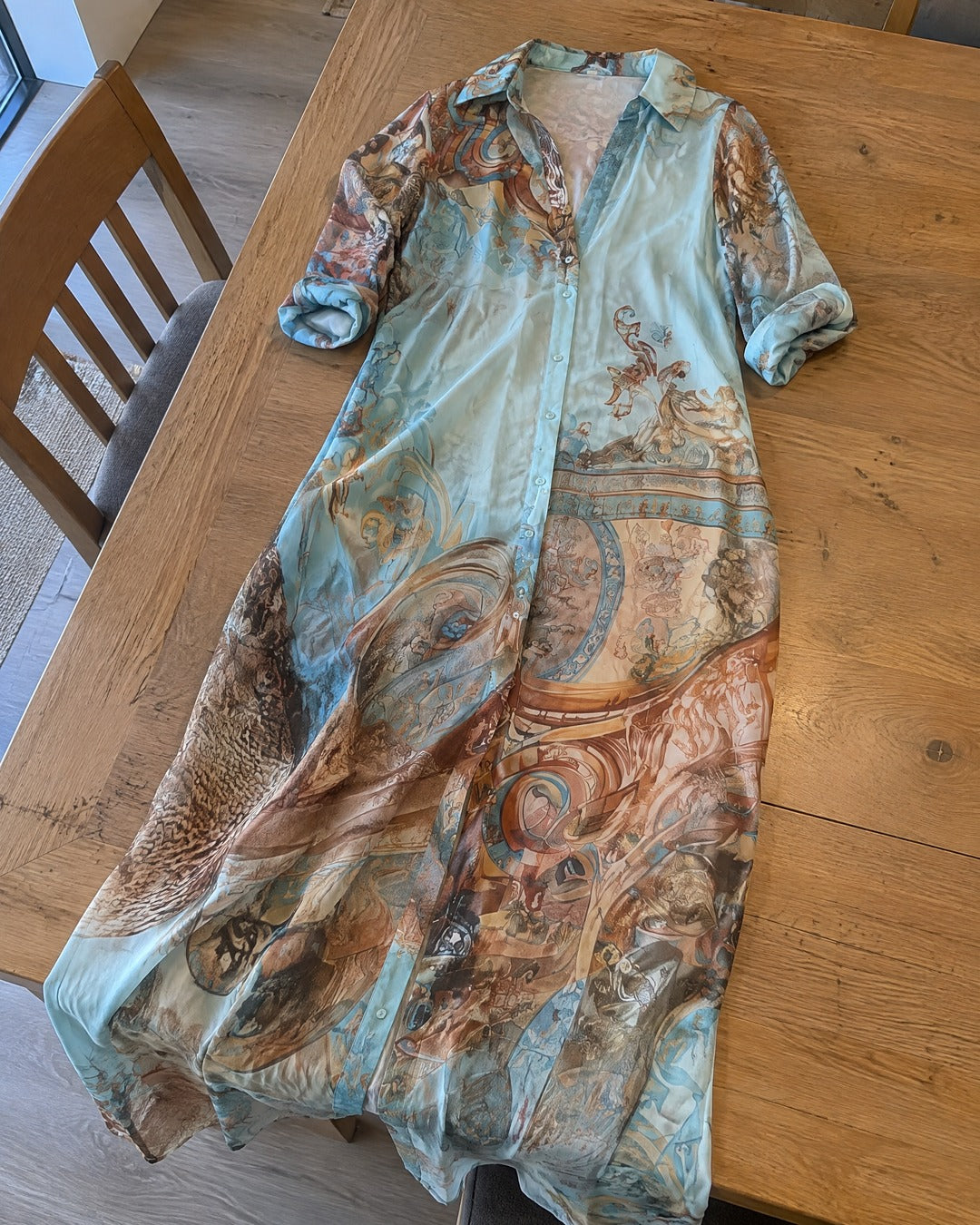 Isabella blue gold floral long shirt dress on dining table showing rolled sleeves and skirt