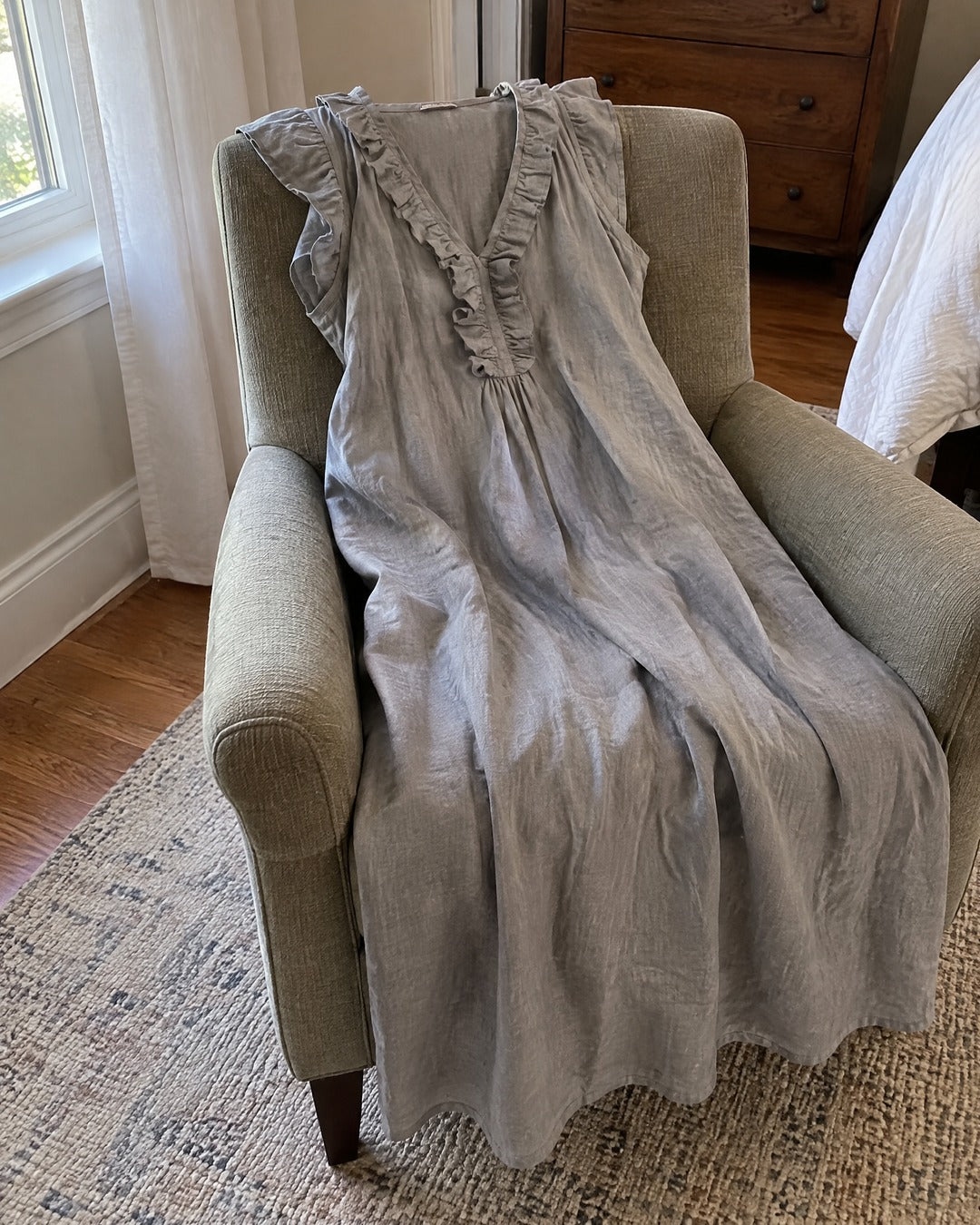 Josette grey ruffle cap sleeve V neck dress over a bedroom armchair