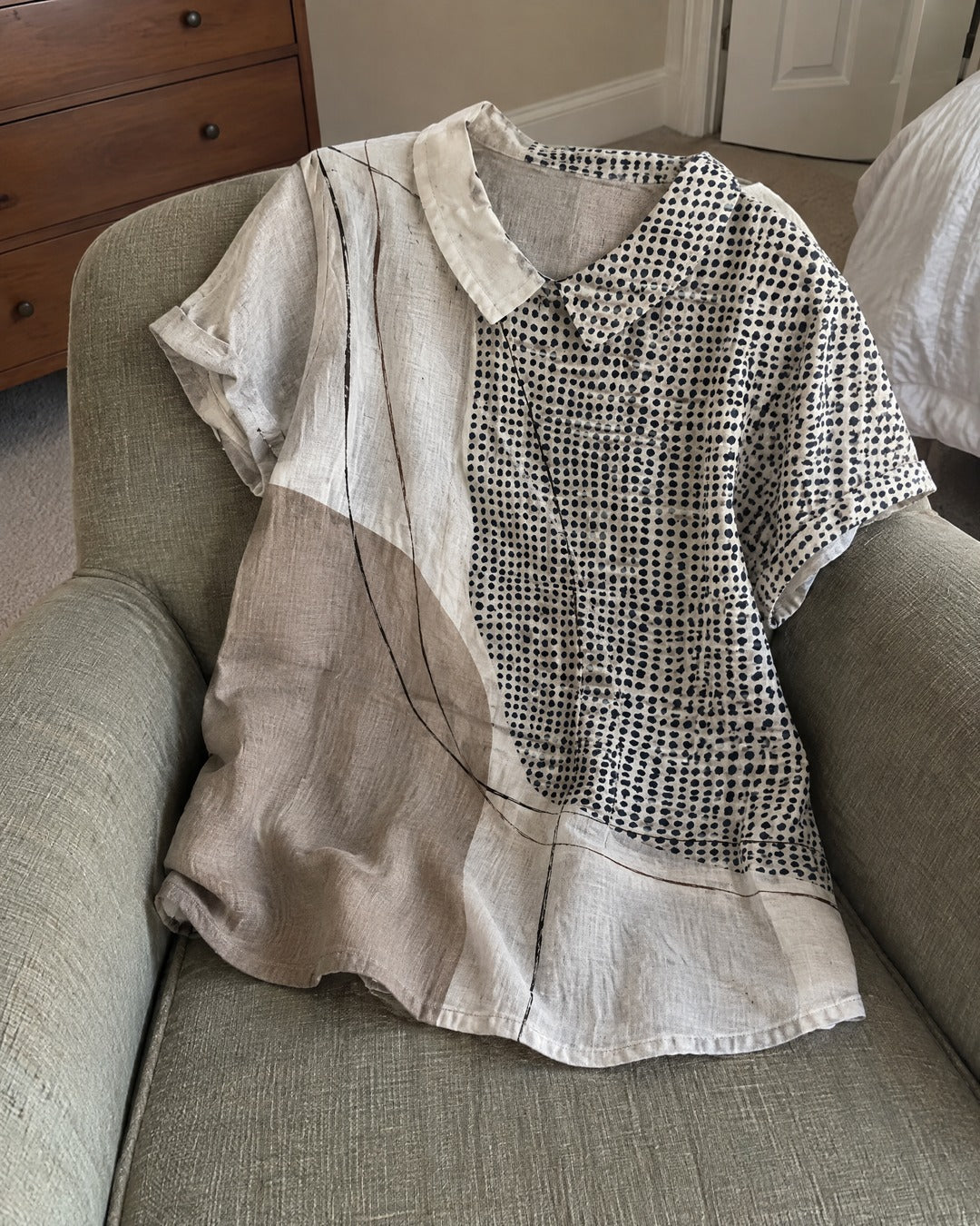 Lana abstract pattern short sleeve shirt draped over armchair in home