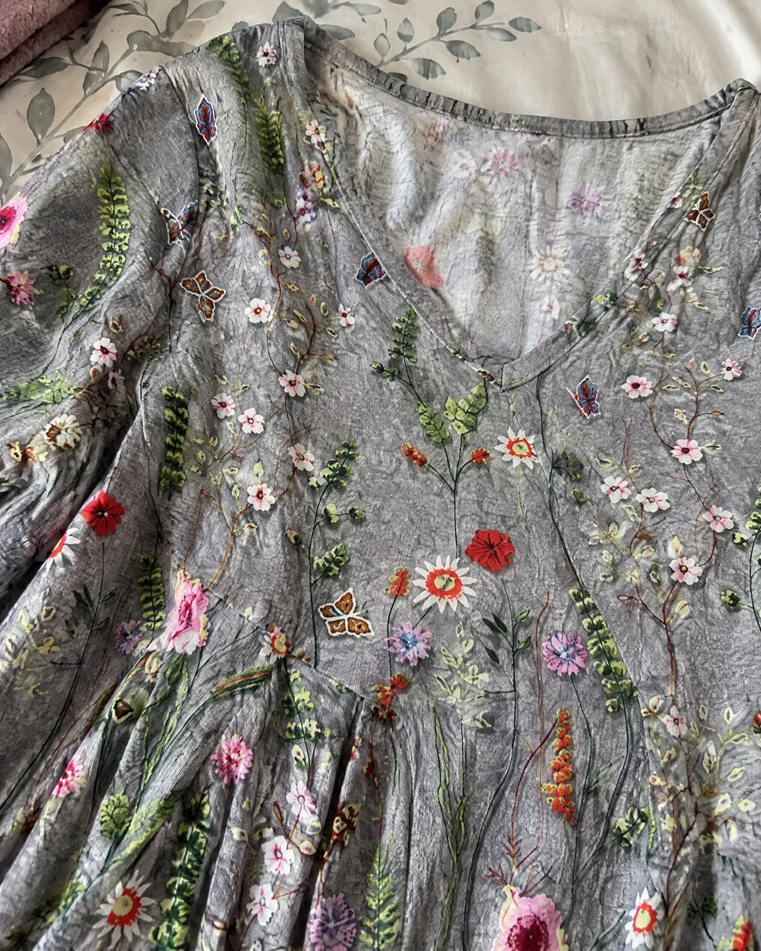 Close up of Lana blouse V neckline soft grey fabric and floral pattern