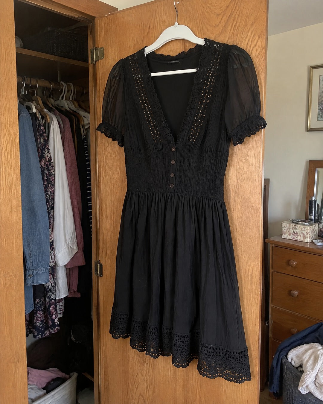 Vivienne black lace trim dress hanging on bedroom wardrobe door