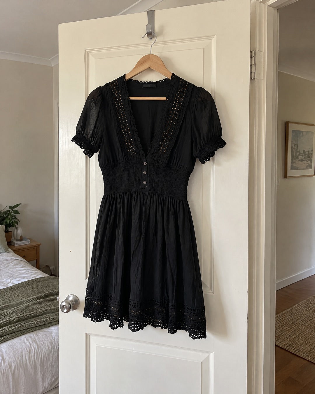 Vivienne lace trim black dress hanging from white bedroom door