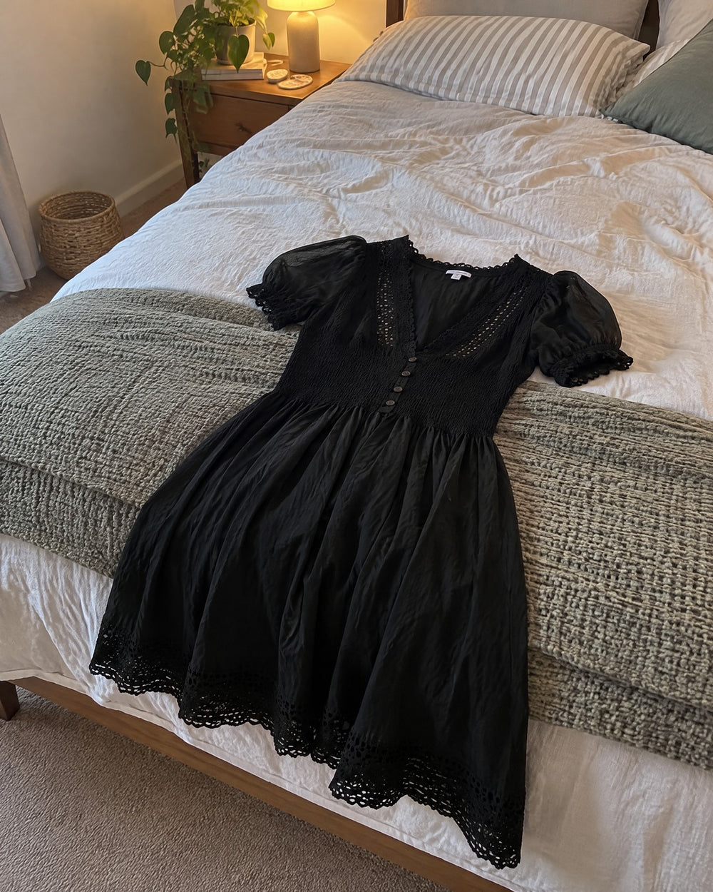 Vivienne black lace dress laid across the foot of a bed