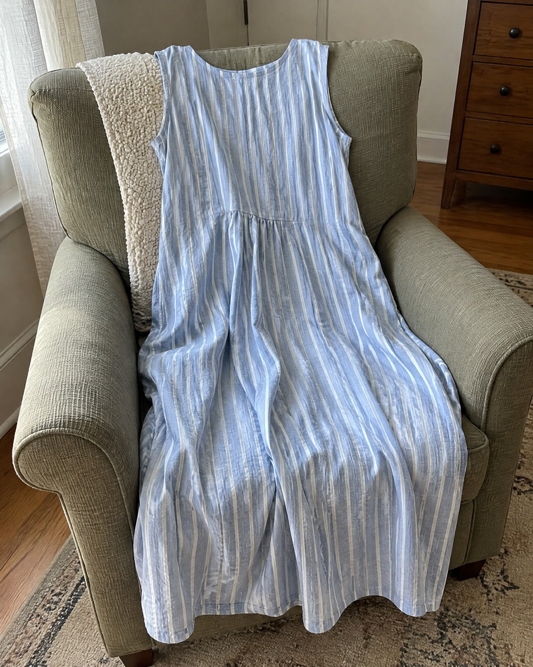 Dina blue striped midi dress draped over an armchair
