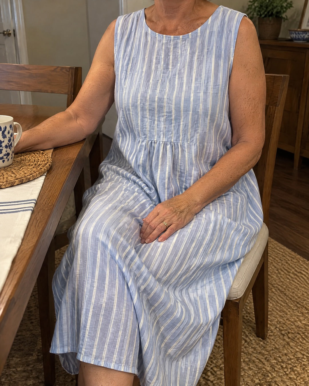 Dina blue striped midi dress worn while sitting at a dining table